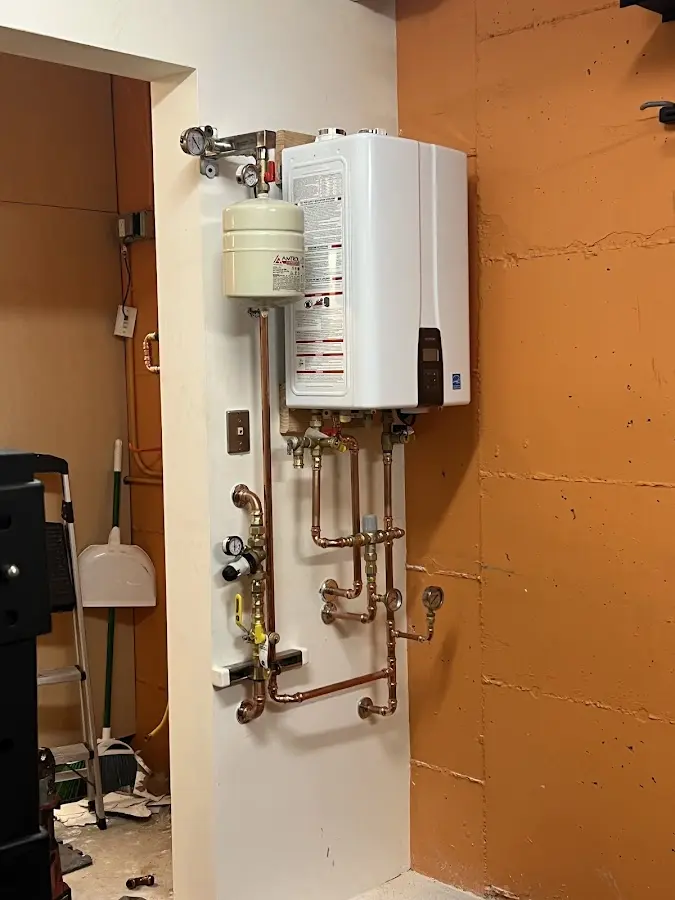 Plumbing technician inspecting water heater connections in Lenoir City